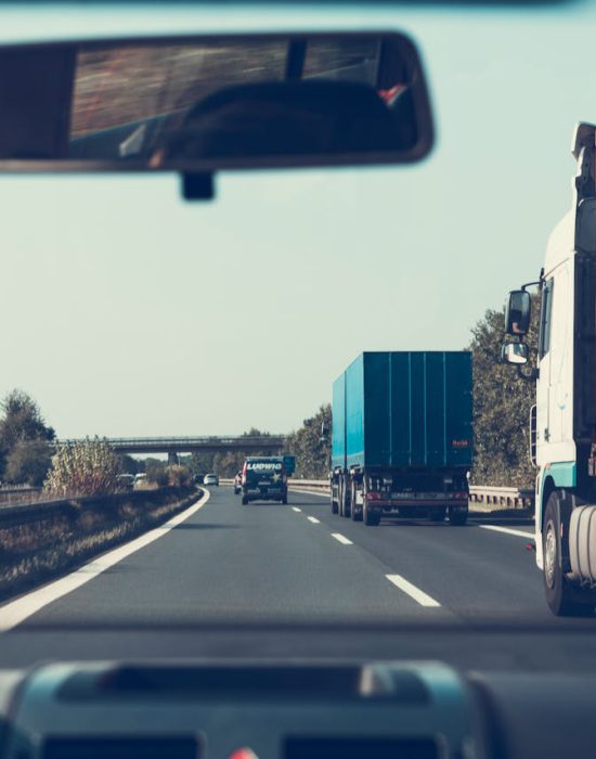 View through rearview mirror of trucks on a German highway, driving towards Bamberg.